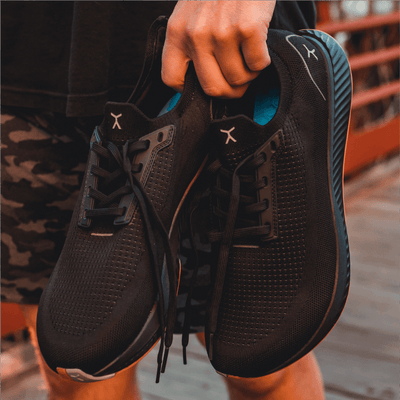 Person holding Black shoe with Gum Sole Running Shoe #color_black-gum-rn