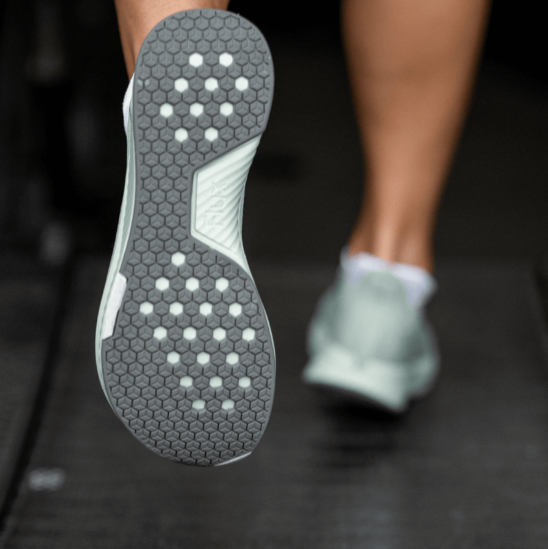 Heel/sole view of woman running in shoe 